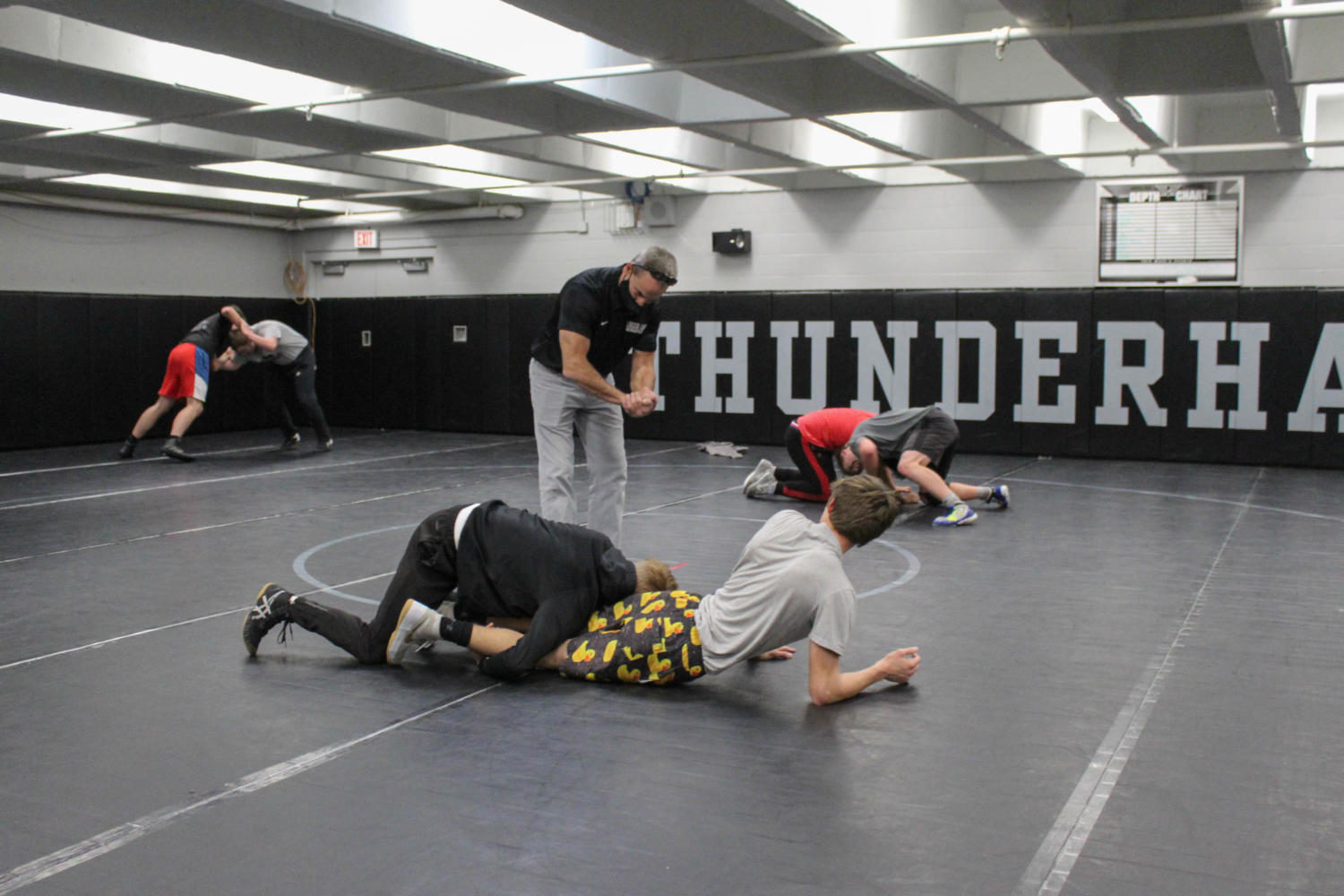 Under+the+watch+of+veteran+coach+Scott+Fetzer%2C+East+wrestlers+follow+their+new+safety+protocols+during+practice+by+sticking+to+one+opponent+and+spacing+out+on+the+mat.