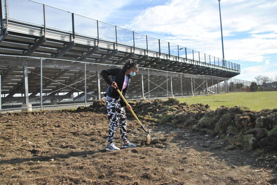 Former East student Megan Sheth helps dig a spot for the new East Eco-Classroom 