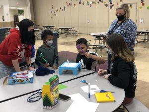 East seniors Kiley Doll (far left) and Megan Davis (far right) work with Wyandot students on an activity. 