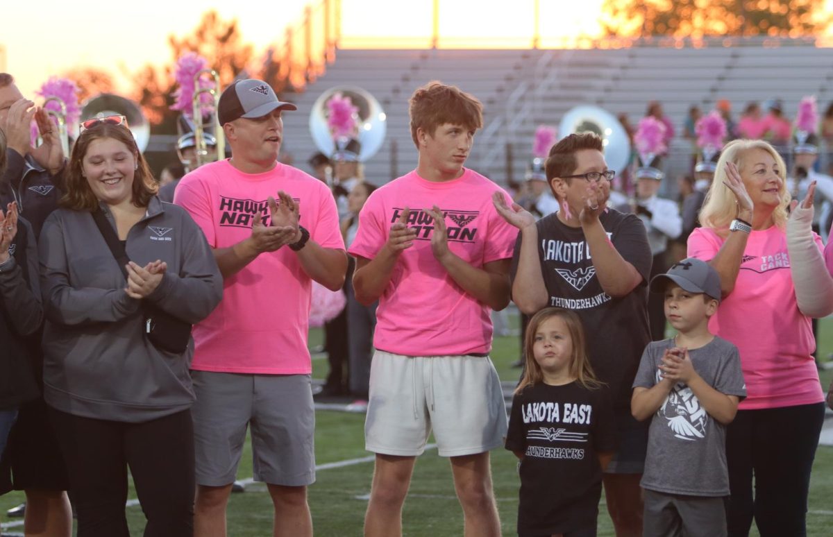 Cancer survivors are honored at a Crucial Catch event. Their friends and families surround them before kickoff at a football game between East and Sycamore.