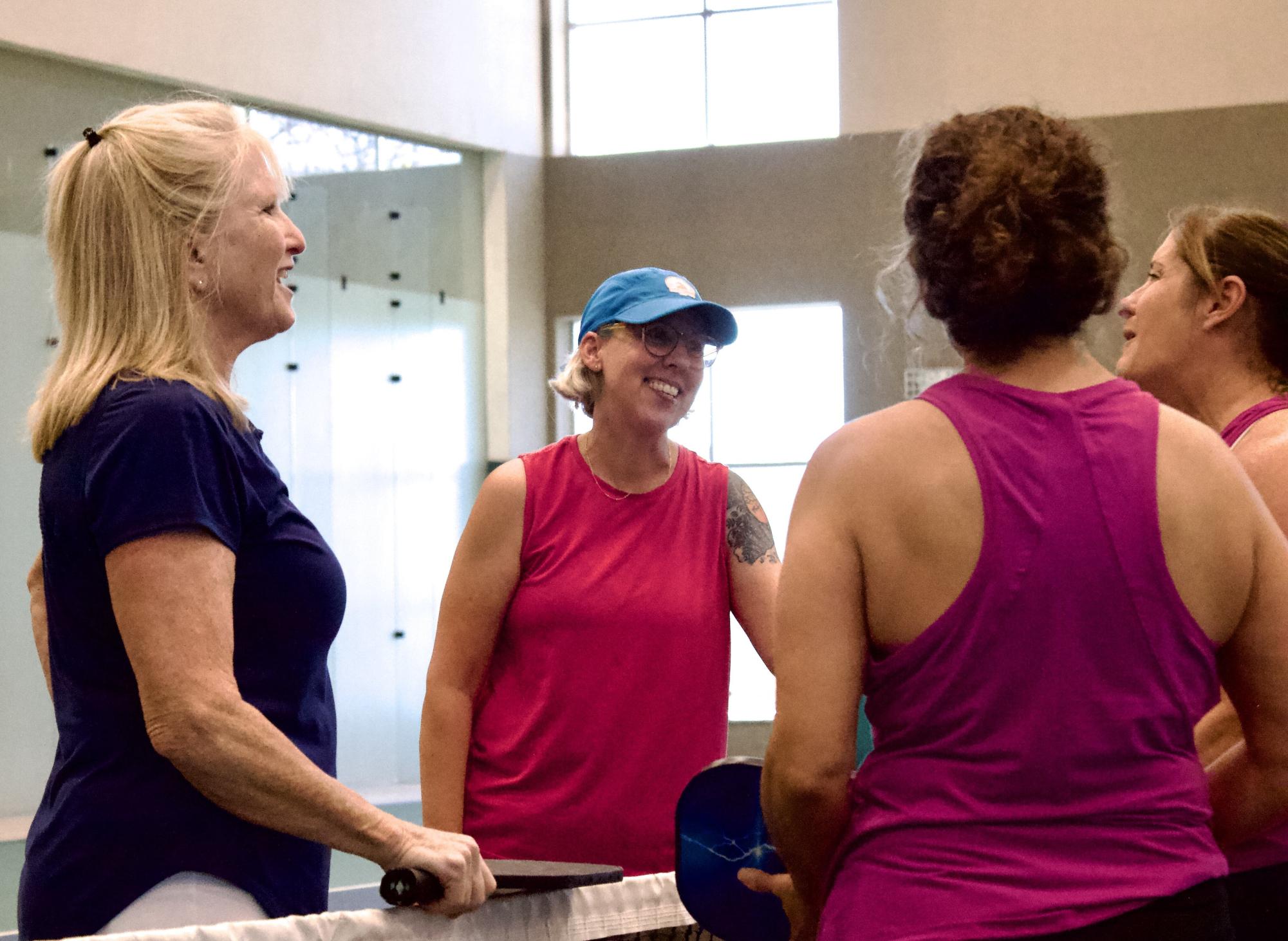 Peggy Coggins (right) and Dusty Columbia (middle) greet their pickleball opponents. Coggins rose over $1,000 to donate to the Dragonfly Foundation for her 70th birthday.