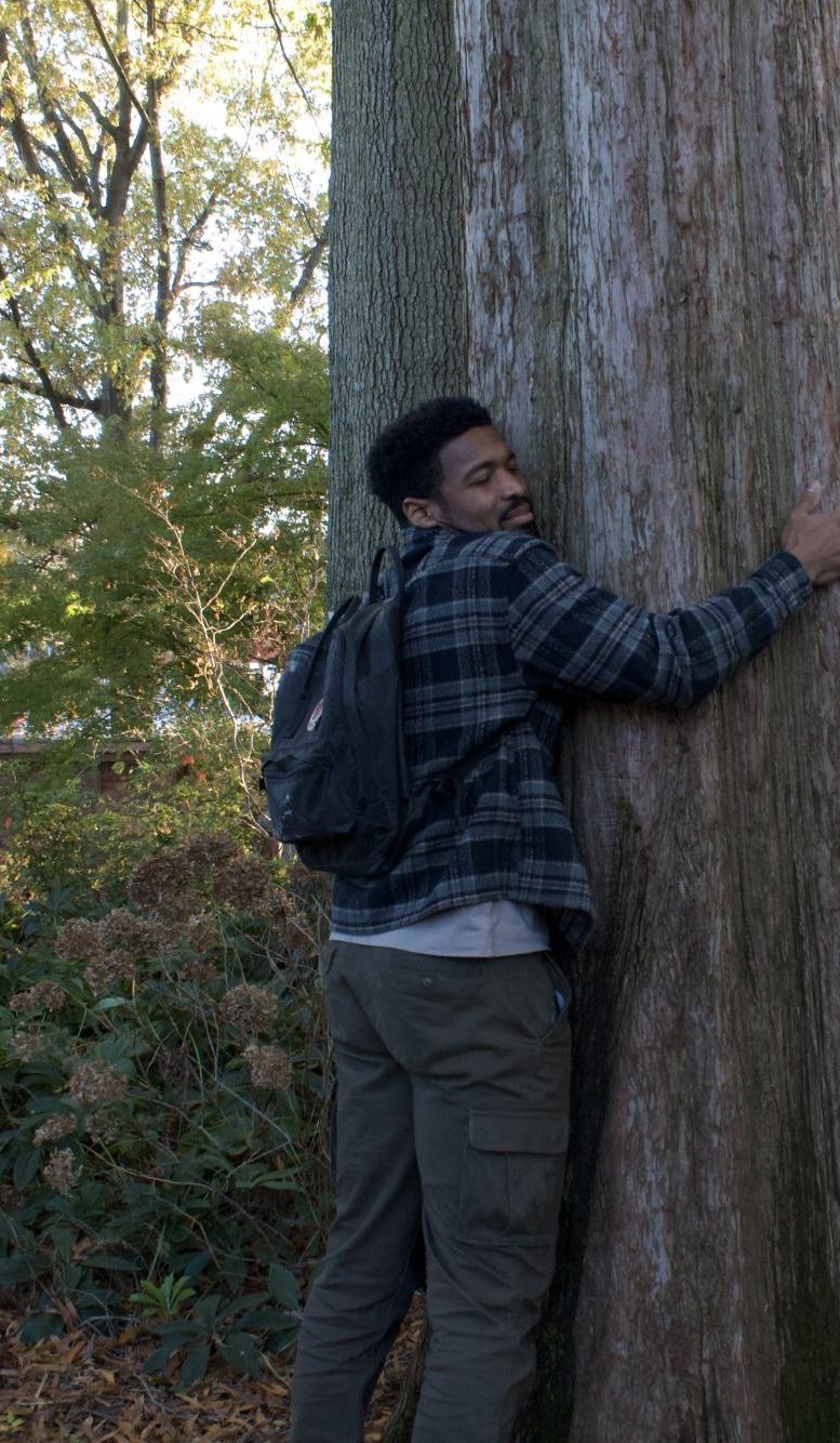 Brandon Reynolds embraces his favorite “hugging tree”, as he calls, it during a tour of Haucke Botanical Garden. Haucke houses a diverse variety of gardens, growing everything from herbs and spices to their a newly planted butterfly garden.