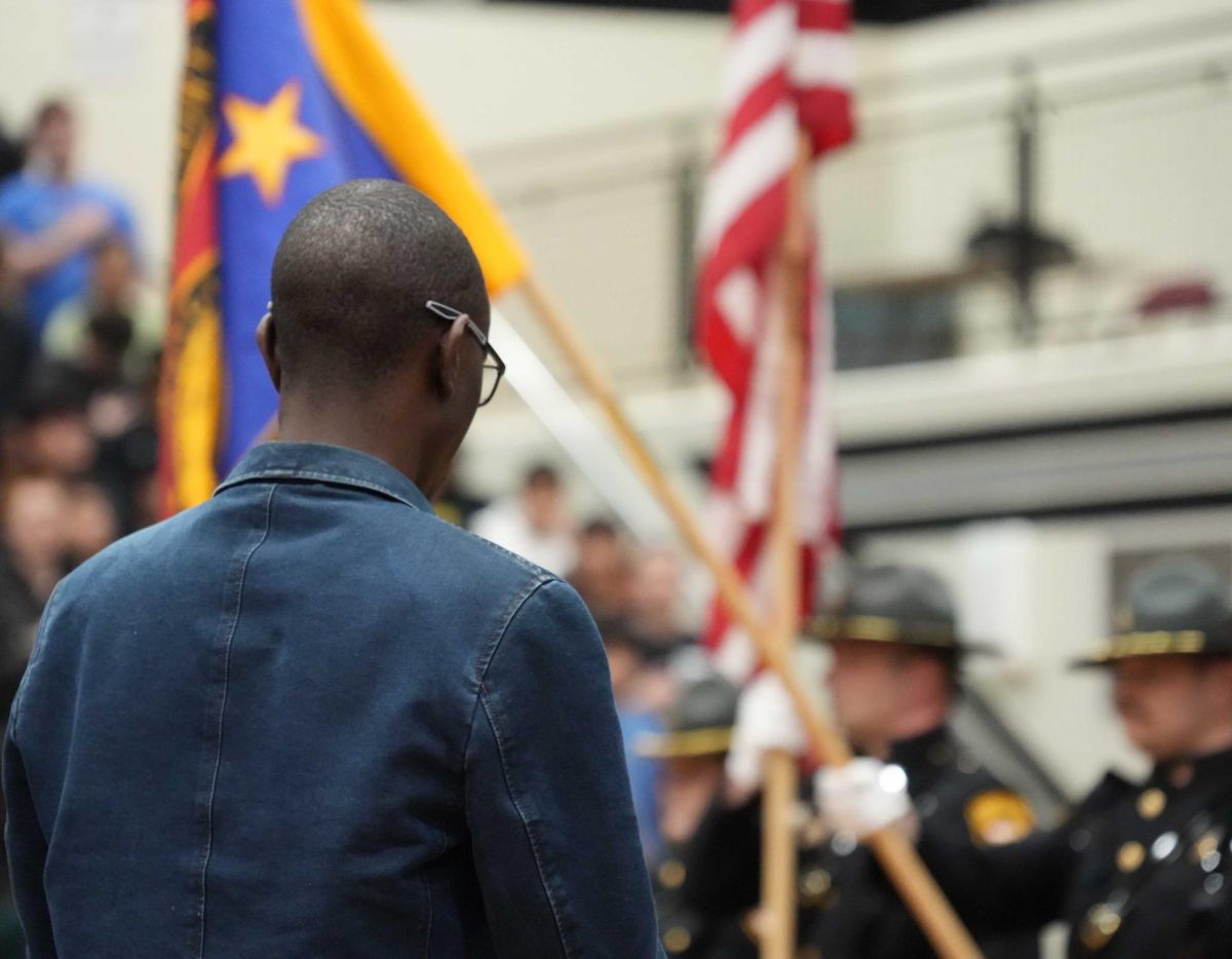 Liamme Thiam stands during the presentation of the colors. He was present to support his wife being naturalized.