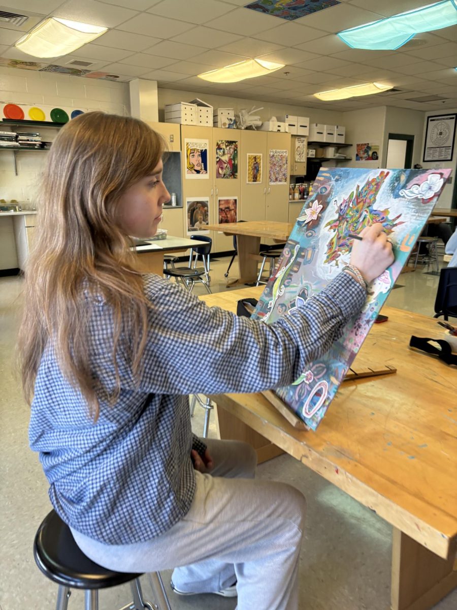 Focus. Lauren created this abstract piece using mixed media on cardboard. She adds the finishing touches with a colored pencil.