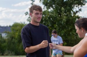 Flynn Prather fist-bumps East senior Brooks Billingsley during cross country practice on Sept. 3, 2025. The warm weather and clear skies offered good running conditions.